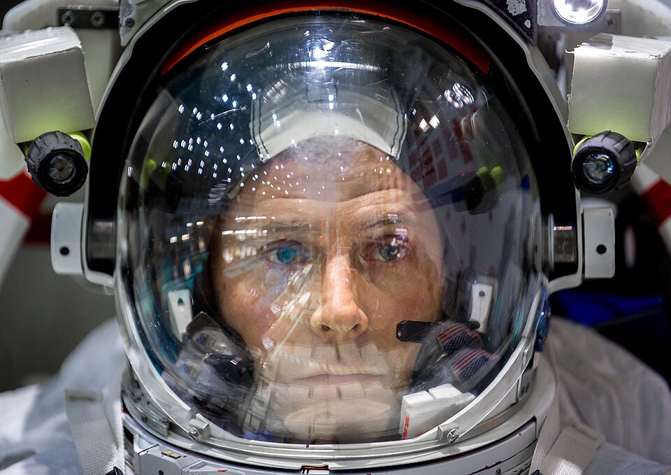 NASA astronaut Col. Tyler N. 'Nick' Hague waits to be lowered into the pool containing a mockup of the International Space Station by J.M. Eddins Jr. Public domain NASA.